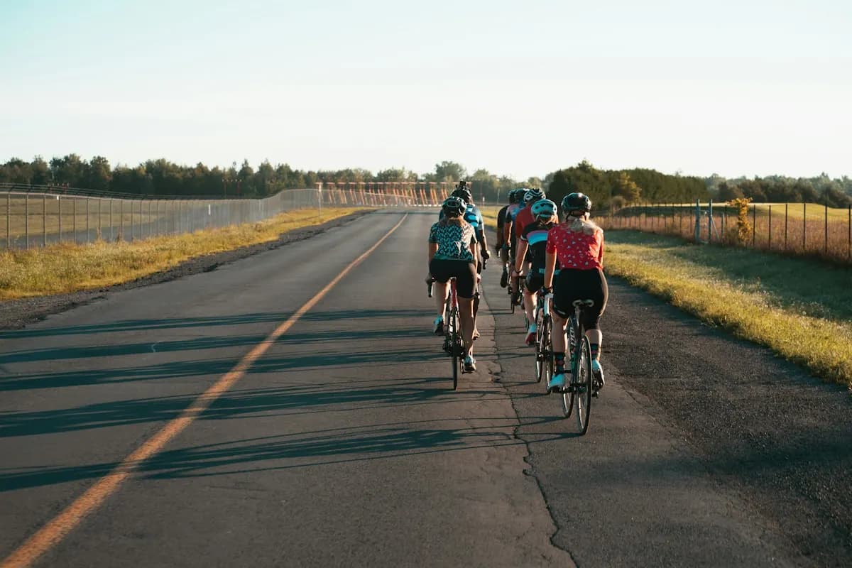 A group of cyclists riding a quiet country road