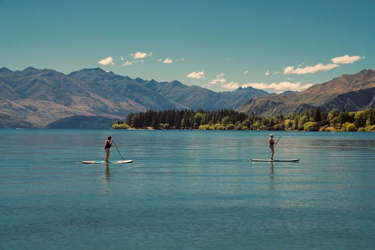 Two paddleboarders on a calm mountain lake